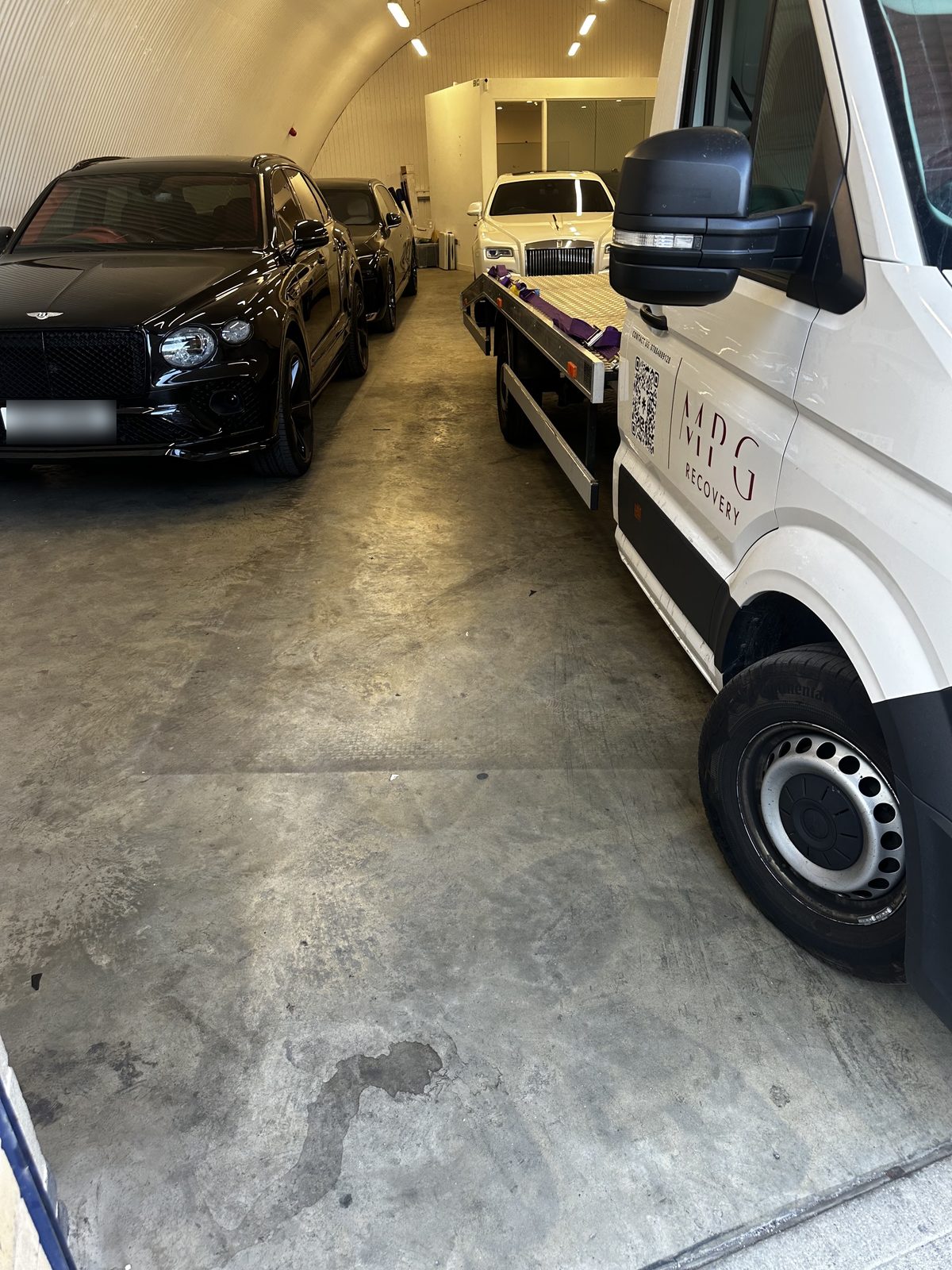 Vehicles parked inside the MPG Recovery arch in East London beside the recovery truck