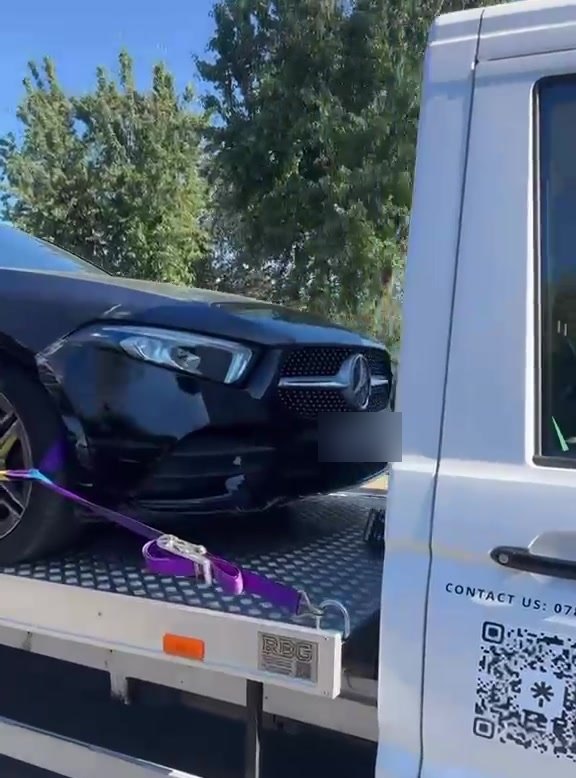 A damaged Mercedes being winched onto the MPG Recovery flatbed