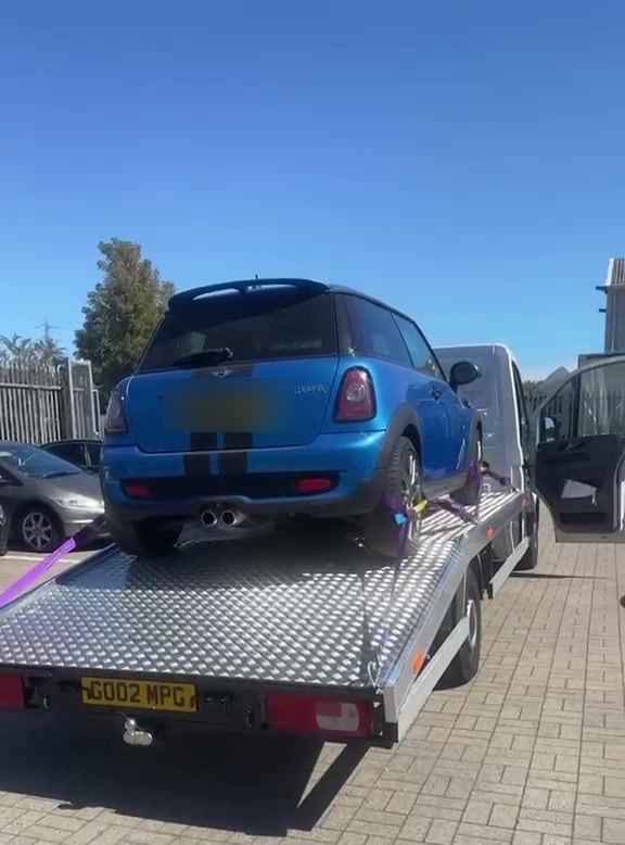 A Mini strapped down on the MPG Recovery flatbed in daylight